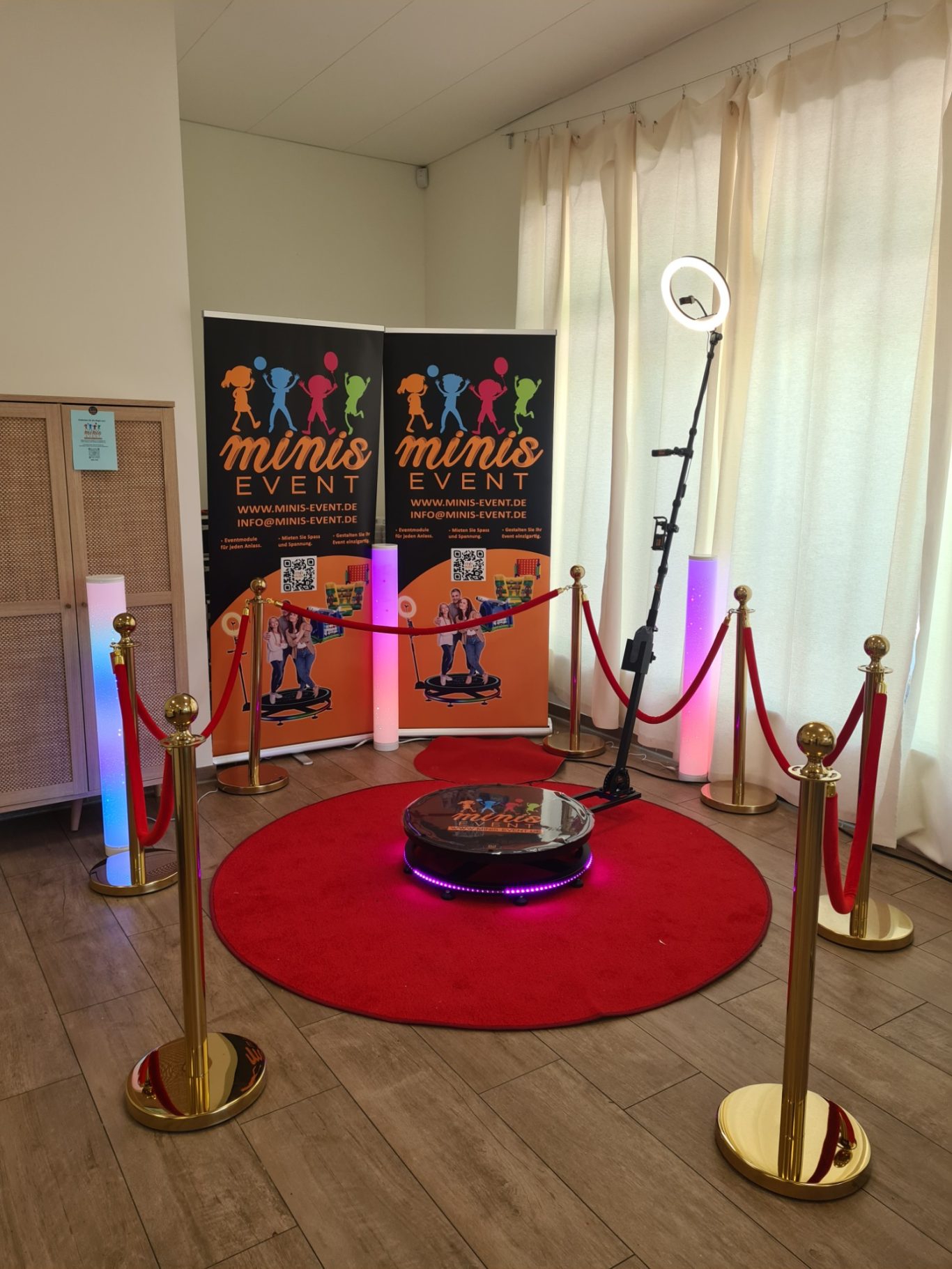 360° Video-Aufnahmen Ein roter Teppich mit Ständern und bunten Lichtern, umrahmt von roten Absperrseilen.